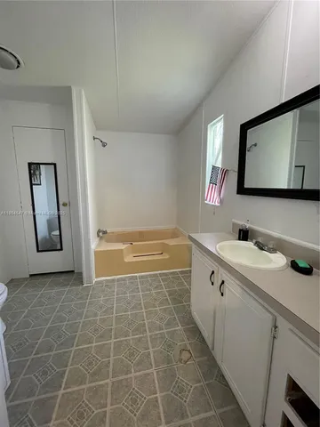 a bathroom with a tub sink and mirror