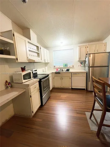 a kitchen with stove cabinets and wooden floor
