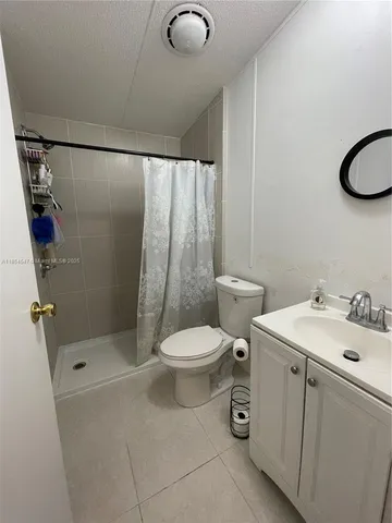a bathroom with a toilet sink a shower and a mirror