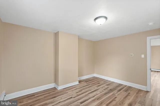a view of an empty room with wooden floor