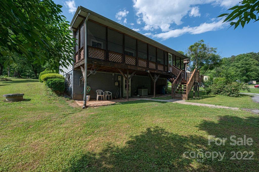 4254 Hartland Road Lenoir, NC 28645 - Photo 12 of 47 a view of a wooden house with a big yard and large trees