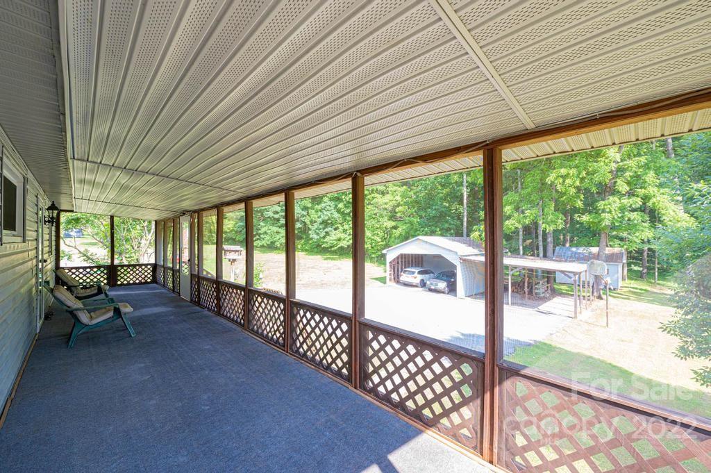 4254 Hartland Road Lenoir, NC 28645 - Photo 16 of 47 a view of a patio with table and chairs next to a yard
