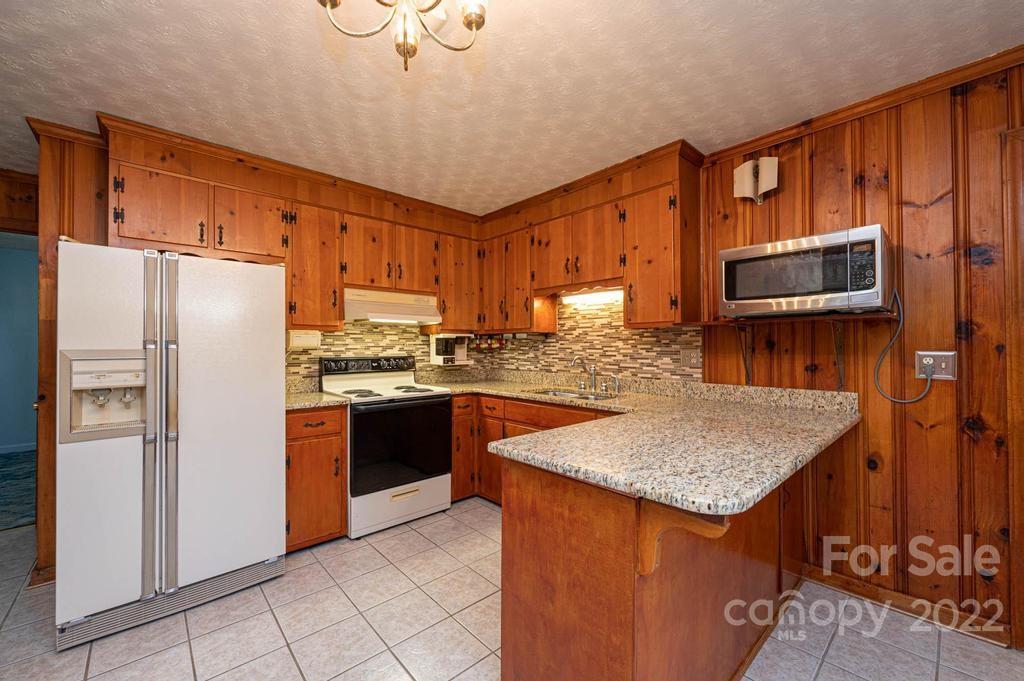 4254 Hartland Road Lenoir, NC 28645 - Photo 22 of 47 a kitchen with stainless steel appliances granite countertop a refrigerator a stove a sink and a microwave