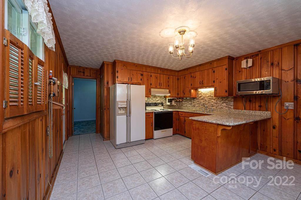 4254 Hartland Road Lenoir, NC 28645 - Photo 23 of 47 a kitchen with stainless steel appliances granite countertop a stove refrigerator and a microwave oven