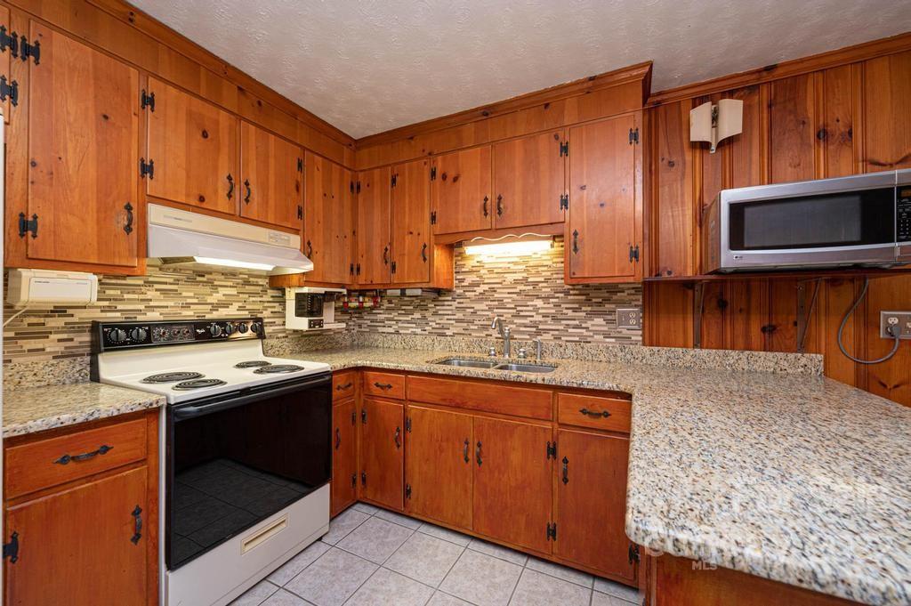 4254 Hartland Road Lenoir, NC 28645 - Photo 26 of 47 a kitchen with stainless steel appliances granite countertop wooden cabinets a stove top oven a sink and dishwasher