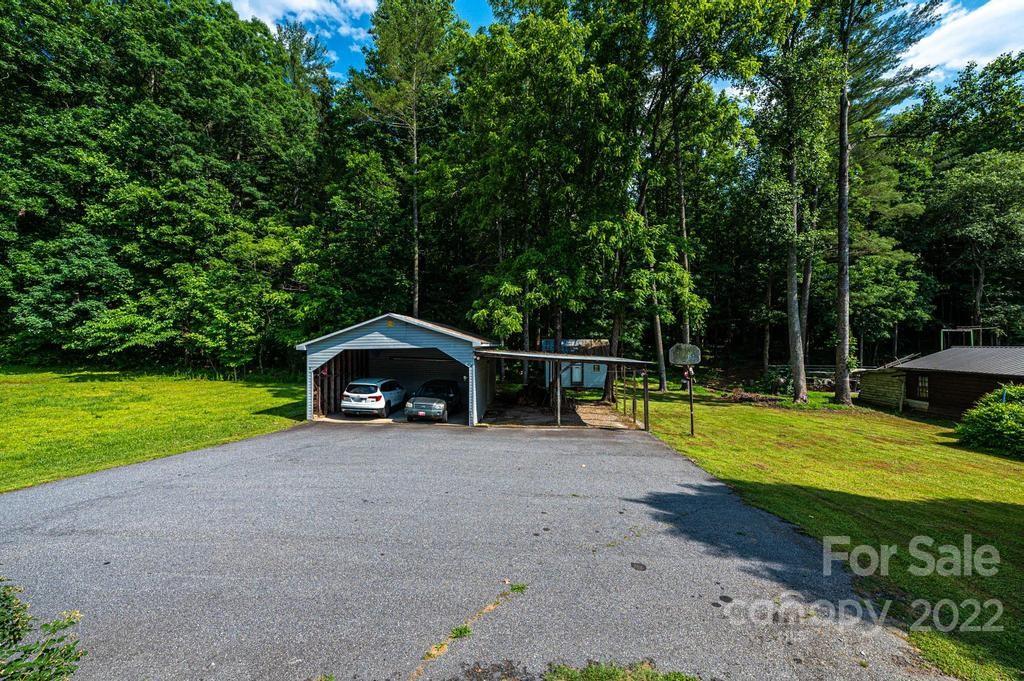 4254 Hartland Road Lenoir, NC 28645 - Photo 43 of 47 a view of a swimming pool with a yard and large trees