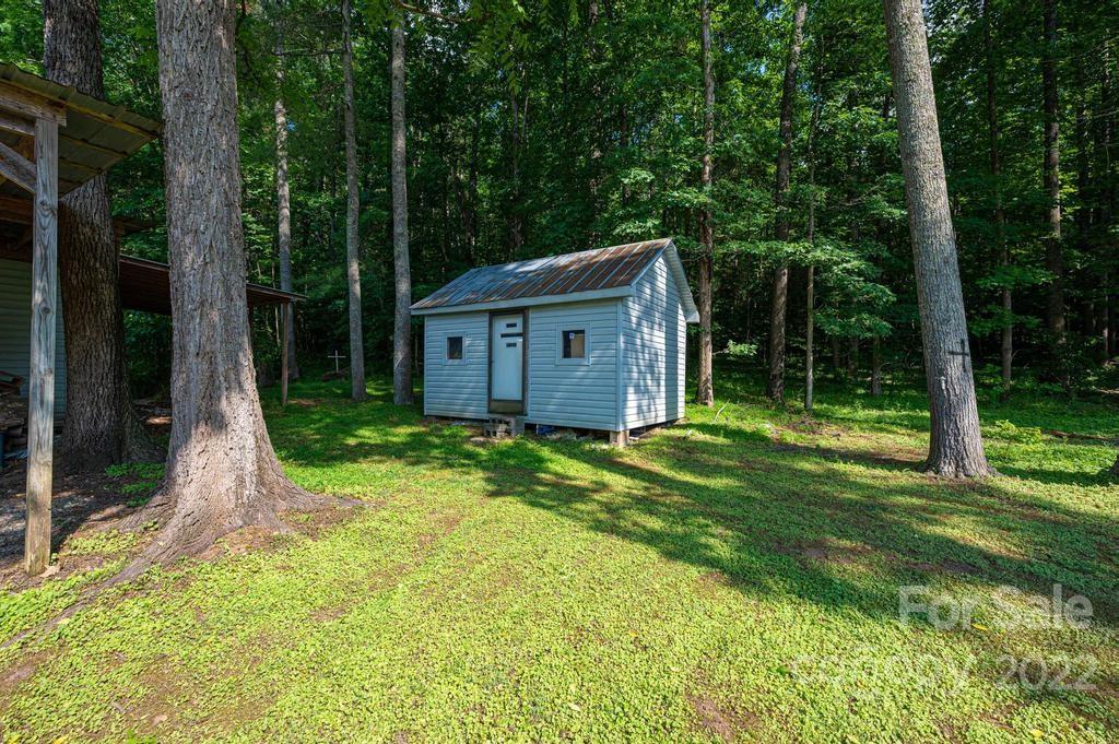 4254 Hartland Road Lenoir, NC 28645 - Photo 46 of 47 a view of a wooden house with a big yard and large trees