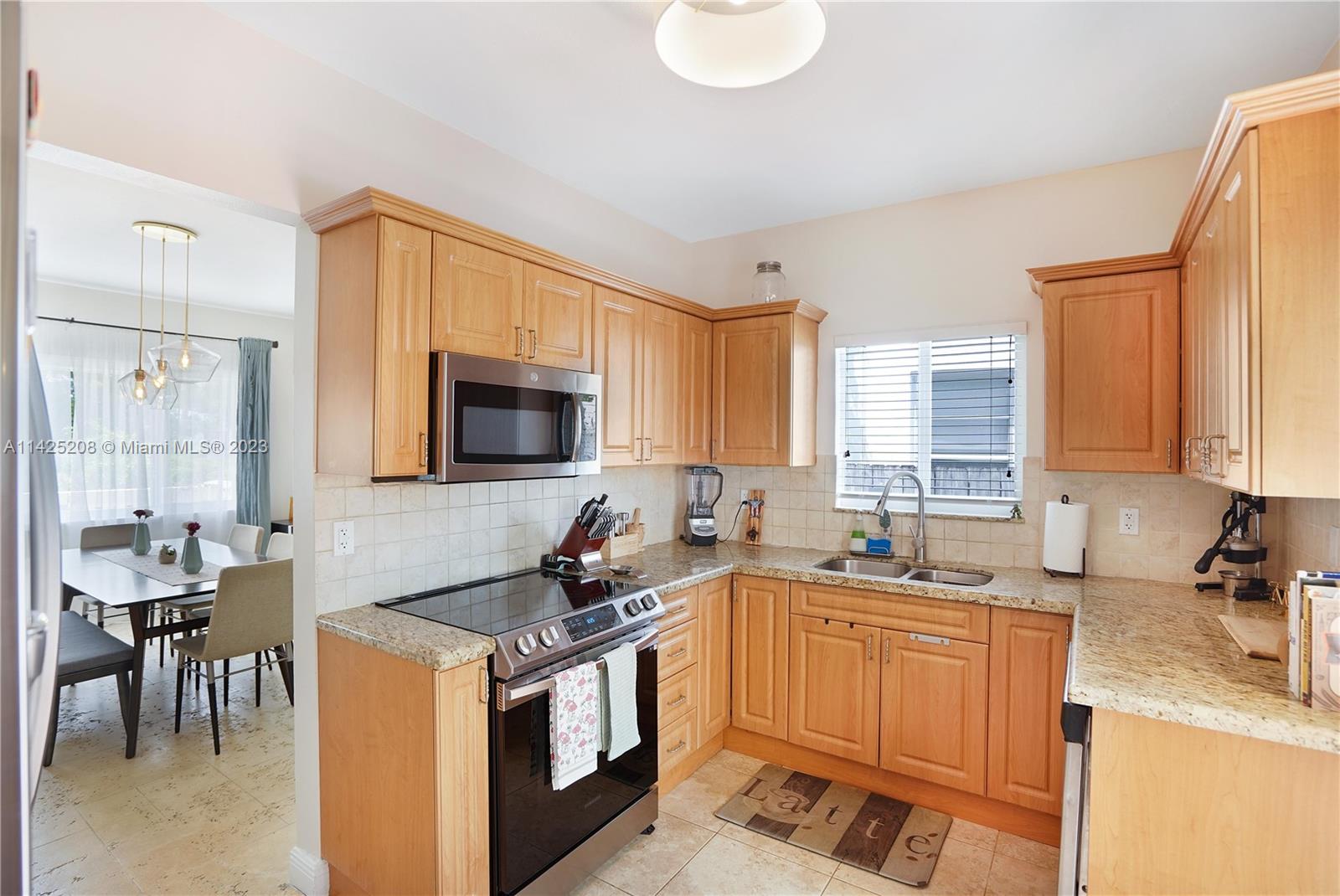 2235 Southwest 11th Terrace Miami, FL 33135 - Photo 22 of 43 a kitchen with stainless steel appliances granite countertop a sink stove and cabinets