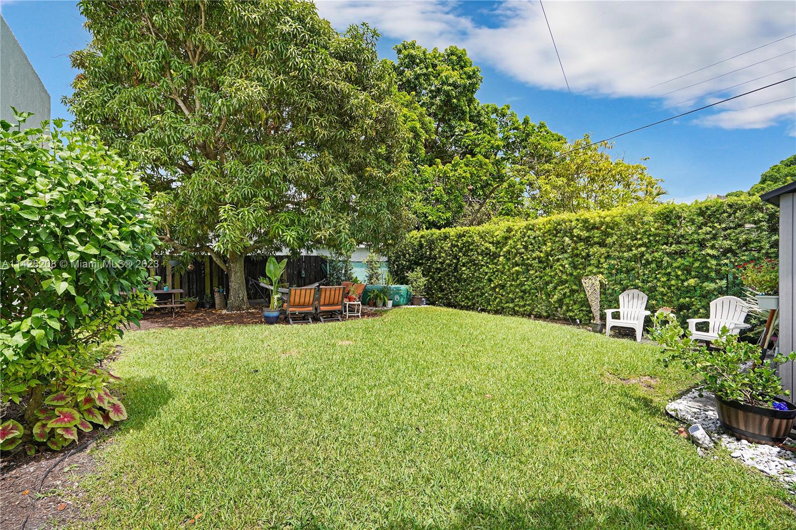 2235 Southwest 11th Terrace Miami, FL 33135 - Photo 41 of 43 a backyard of a house with table and chairs plants and large trees