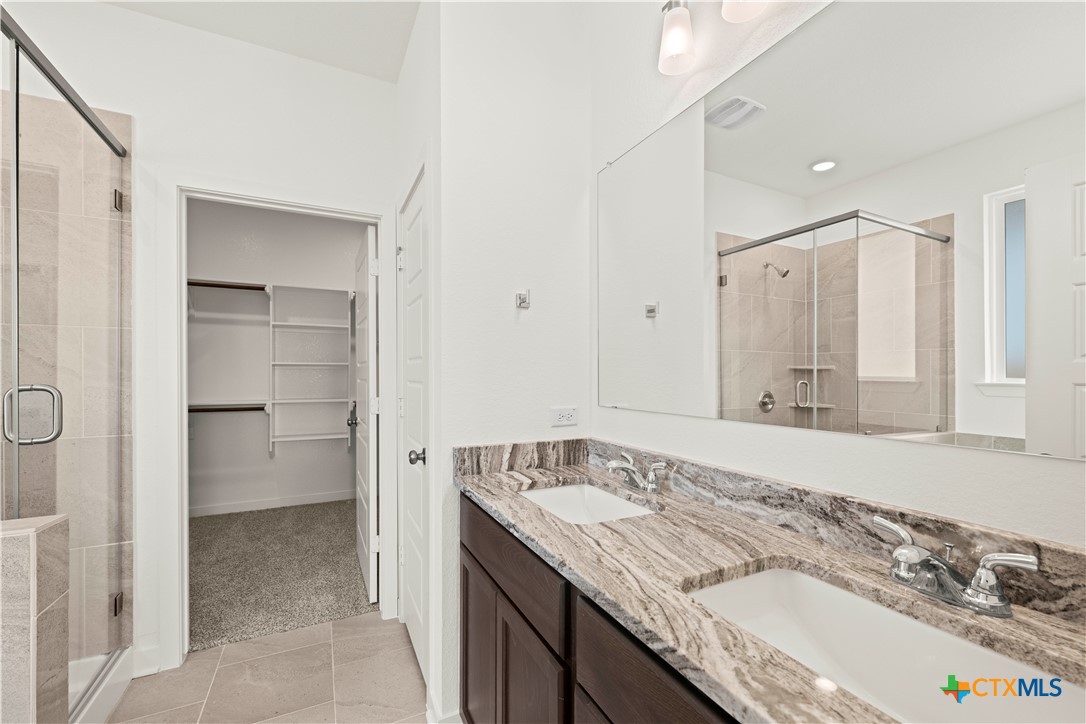 7715 Krenek Tap Drive Temple, TX 76502 - Photo 19 of 30 a bathroom with a granite countertop sink and a mirror