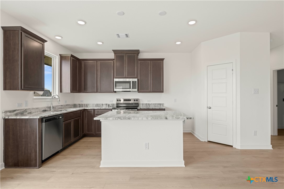 7715 Krenek Tap Drive Temple, TX 76502 - Photo 26 of 30 a kitchen with a stove a sink and a refrigerator