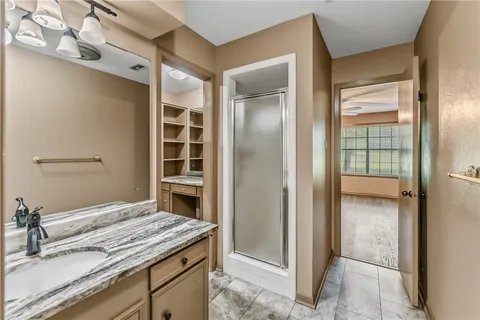 a bedroom with a granite countertop sink and a mirror