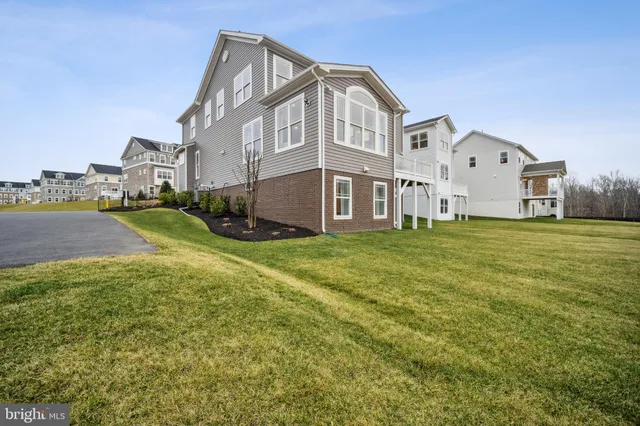 a view of a big house with a big yard and large trees