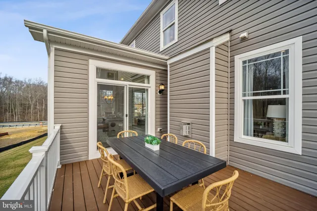 a view of a deck with couches chairs and wooden floor