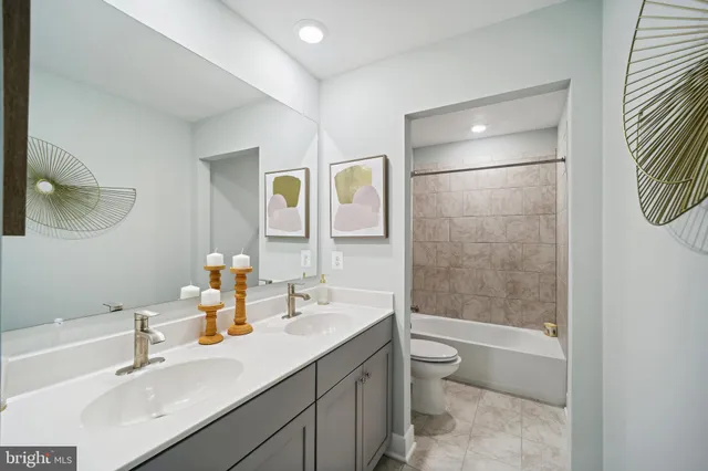 a bathroom with a double vanity sink toilet and shower