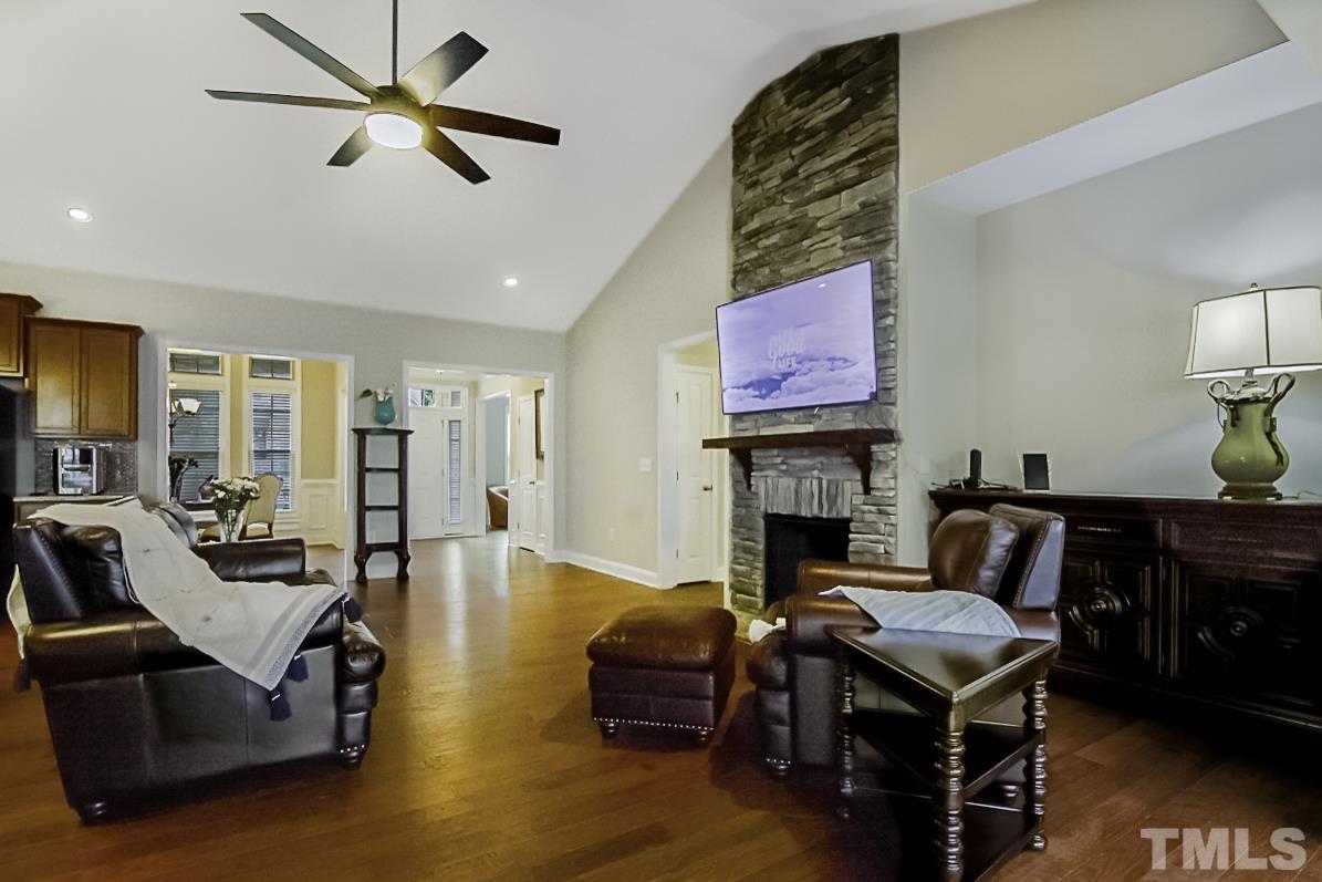 7617 Channery Way Raleigh, NC 27616 - Photo 12 of 42 a living room with furniture a fireplace and a flat screen tv