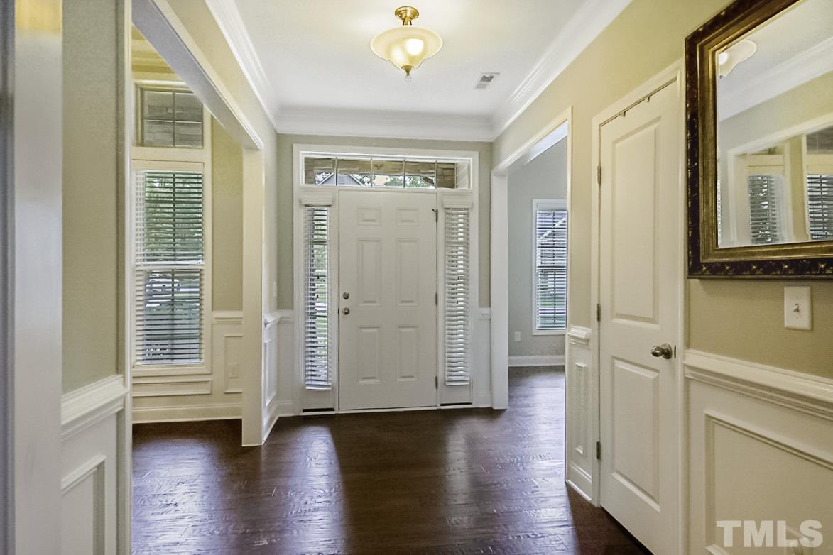 7617 Channery Way Raleigh, NC 27616 - Photo 5 of 42 a view of front door and hallway with wooden floor