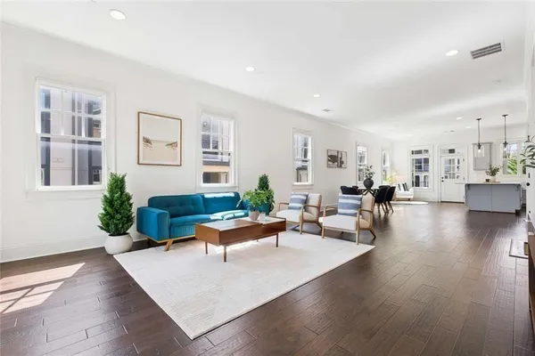 a kitchen with stainless steel appliances granite countertop a refrigerator a sink dishwasher and white cabinets with wooden floor