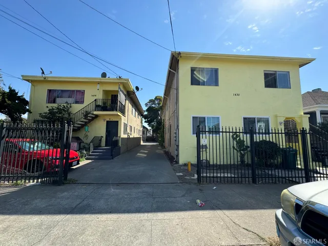 a view of a house with a small yard and wooden fence