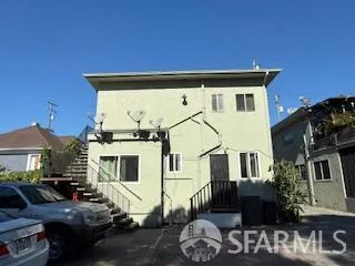 a view of a white house with many windows next to a yard