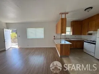 a kitchen with granite countertop a sink cabinets and wooden floor
