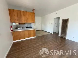 an empty room with wooden floor and a sink