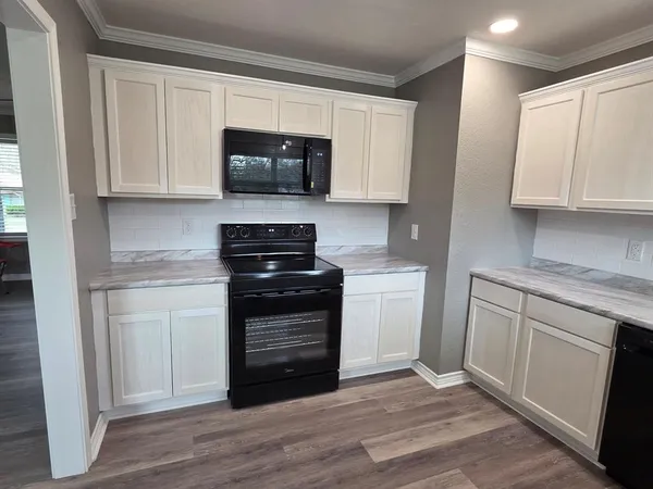 a kitchen with white cabinets and appliances