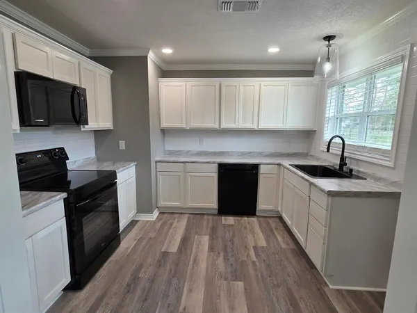 a kitchen with a sink stove and microwave