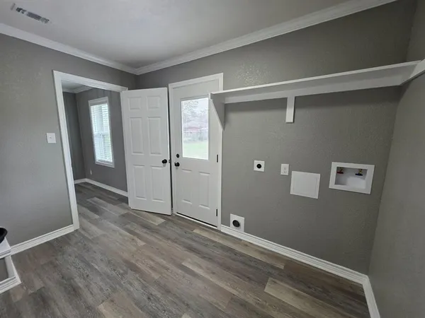 an empty room with wooden floor and mirror