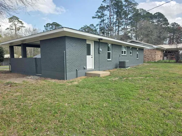 a house with green field in front of it