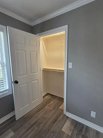 an empty room with wooden floor and closet