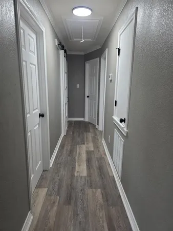 a view of a hallway with wooden floor and staircase