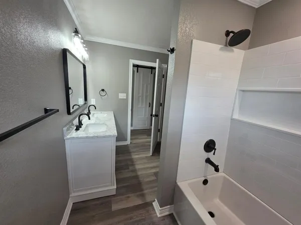 a bathroom with a tub sink and mirror
