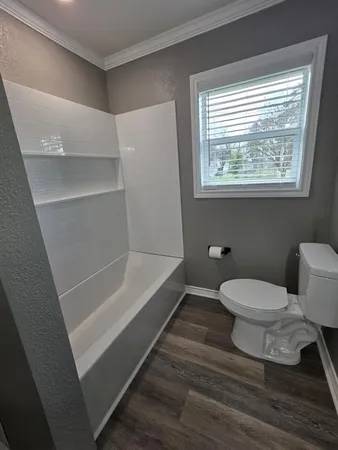 a bathroom with a toilet and a shower