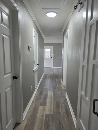 a view of a hallway with wooden floor