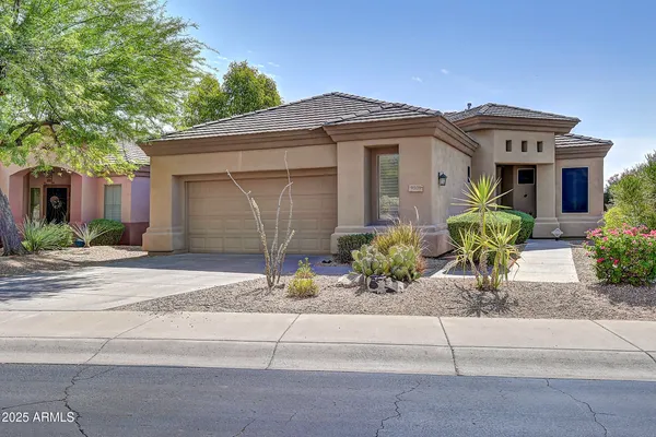 a front view of a house with a yard and potted plants