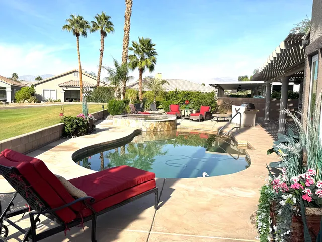a view of a patio with table and chairs potted plants and palm tree