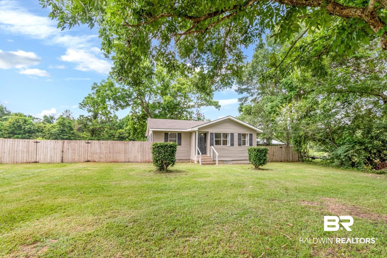 2905A McFarland Road, Unit F Mobile, AL 36695 - Photo 21 of 29 Expansive lawn area featuring a light-colored exterior residence with a dark roof