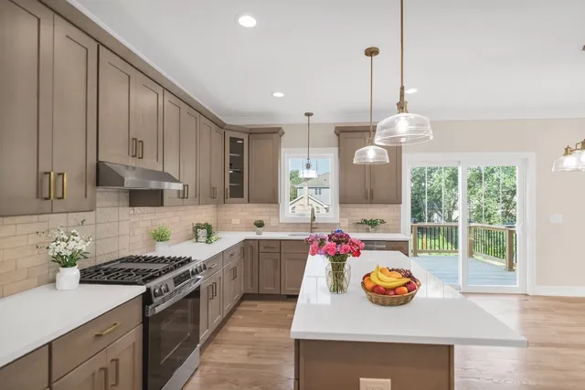 a kitchen with stainless steel appliances granite countertop a stove a sink and a wooden floors