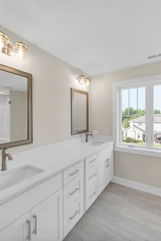a bathroom with 2 sink tub and a mirror
