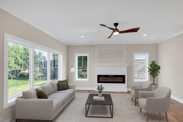 a living room with furniture ceiling fan and a large window
