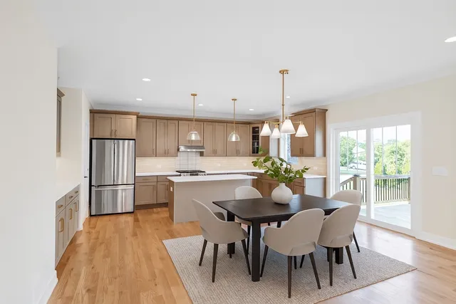 a kitchen with a dining table chairs and refrigerator