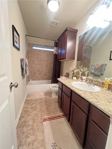 a bathroom with a granite countertop sink a mirror and shower