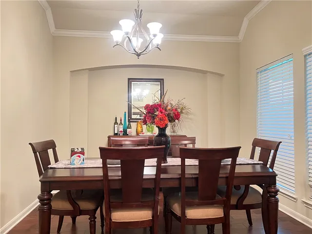 a view of a dining room with furniture a chandelier and wooden floor