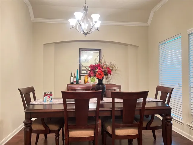a view of a dining room with furniture a chandelier and wooden floor