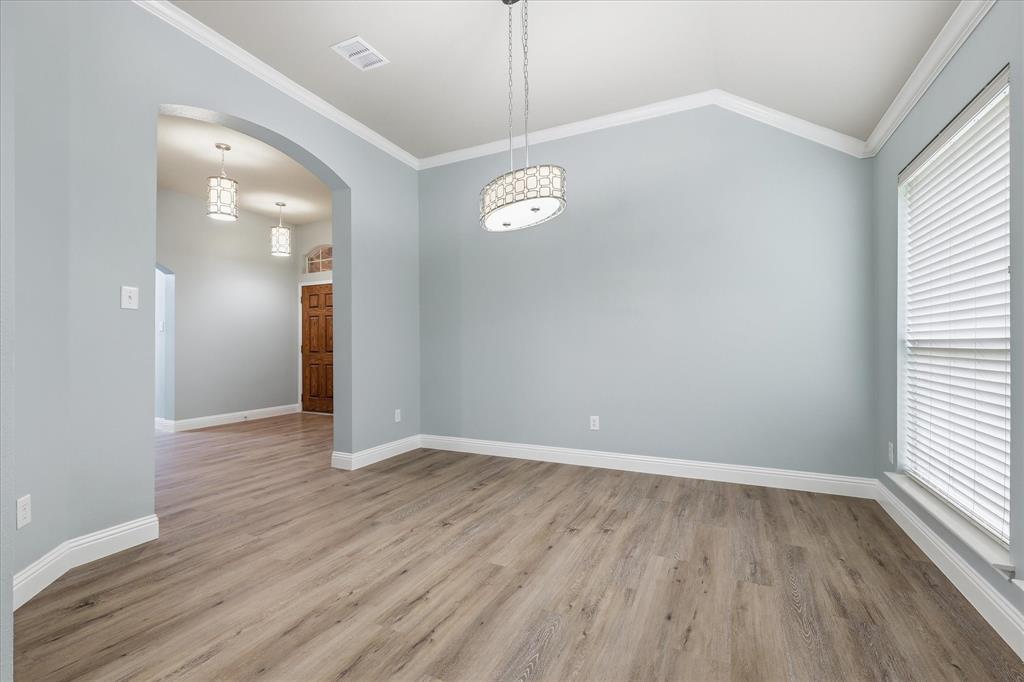 2616 Hollow Ridge Drive Denton, TX 76210 - Photo 6 of 31 Spacious room featuring wood-finish flooring, vaulted ceiling, and an elegant pendant light fixture