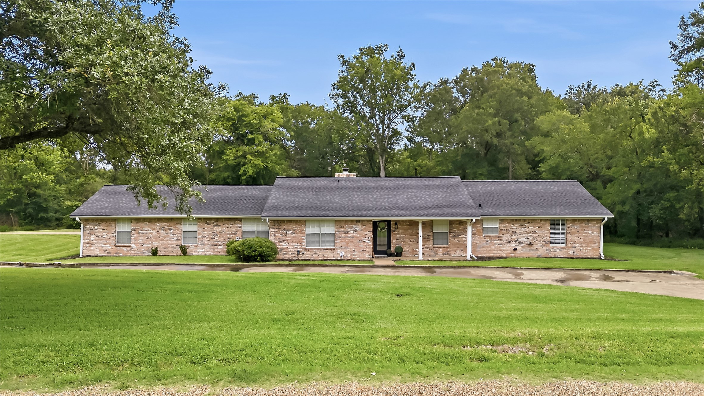 906 Standley Road Madisonville, TX 77864 - Photo 35 of 40 a front view of a house with a garden and trees