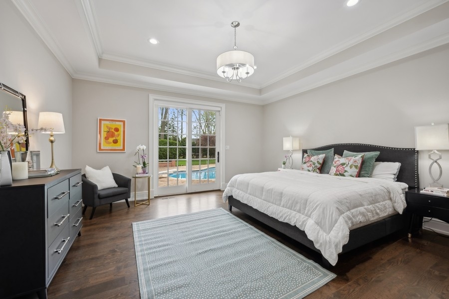 2 Bristol Road Northfield, IL 60093 - Photo 18 of 52 a spacious bedroom with a large bed and a chandelier
