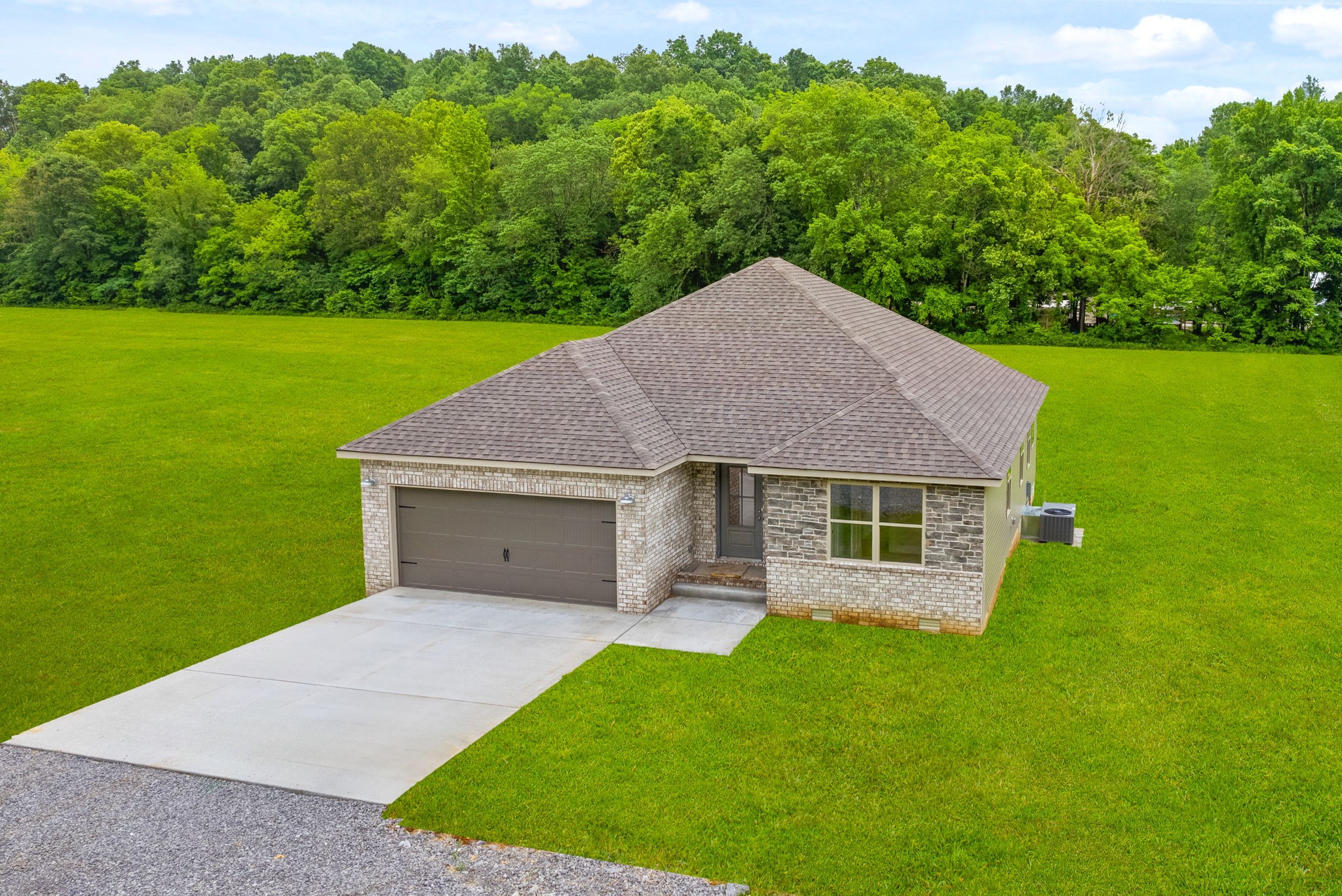 1928 Flats Road Cunningham, TN 37052 - Photo 2 of 49 a house with green field in front of it