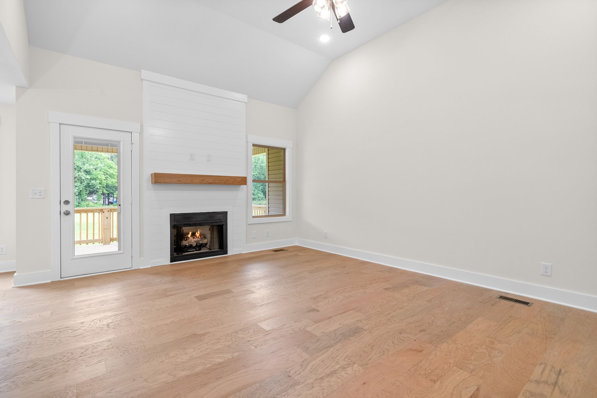 1928 Flats Road Cunningham, TN 37052 - Photo 10 of 49 an empty room with windows fireplace and a ceiling fan